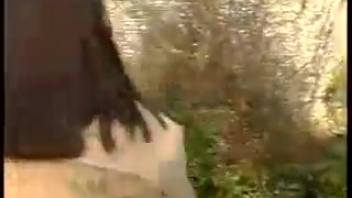 Attractive young woman urinating beside the barrier